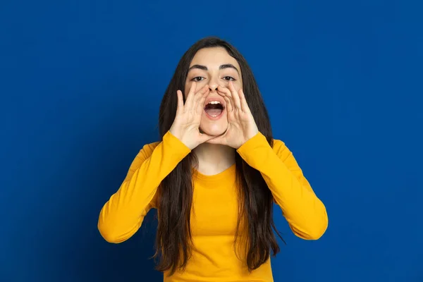 Chica Joven Morena Con Jersey Amarillo Sobre Fondo Azul —  Fotos de Stock