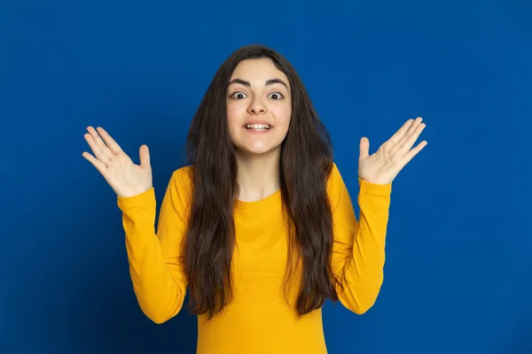 Chica Joven Morena Con Jersey Amarillo Sobre Fondo Azul —  Fotos de Stock