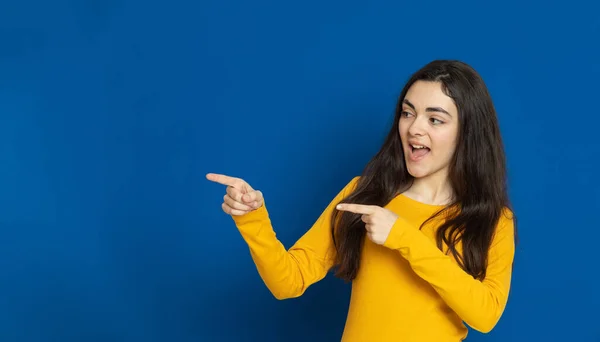 Chica Joven Morena Con Jersey Amarillo Sobre Fondo Azul — Foto de Stock