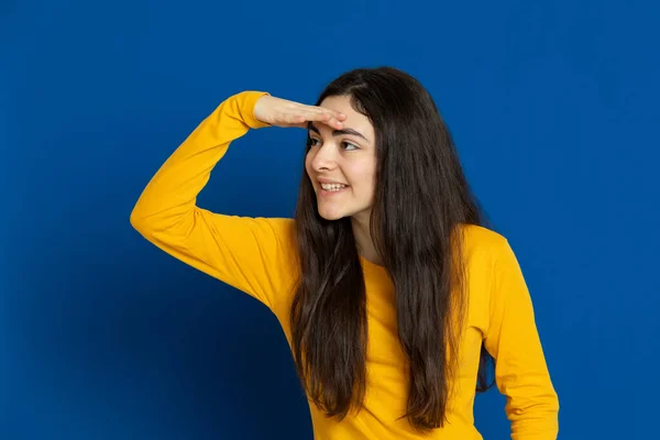 Chica Joven Morena Con Jersey Amarillo Sobre Fondo Azul —  Fotos de Stock