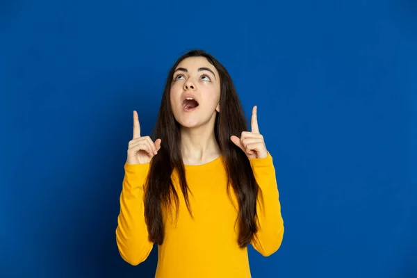 Chica Joven Morena Con Jersey Amarillo Sobre Fondo Azul —  Fotos de Stock