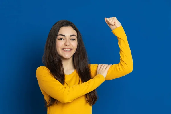 Chica Joven Morena Con Jersey Amarillo Sobre Fondo Azul —  Fotos de Stock