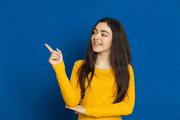 Chica Joven Morena Con Jersey Amarillo Sobre Fondo Azul — Foto de Stock