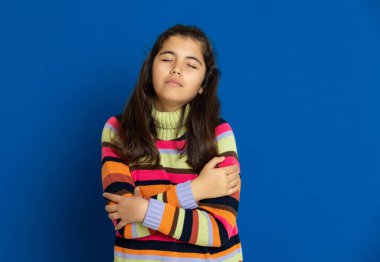 Mavi arka planda çizgili forması olan sevimli bir genç kız.