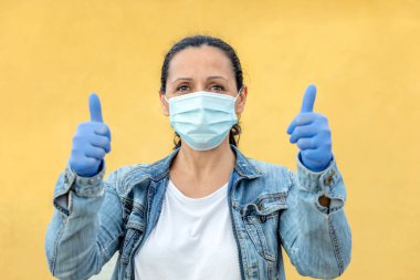 Sağlığını korumak için maske takan esmer kadın.