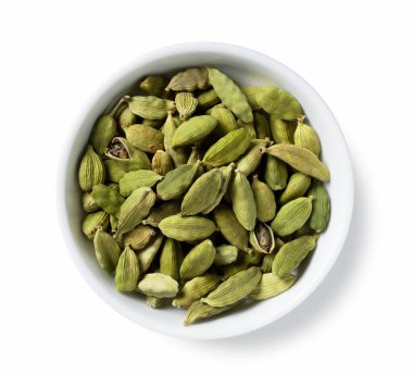 Kakule tohumları beyaz arka plana yerleştirilmiş bir tabakta