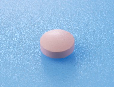 Mavi arka plana yerleştirilmiş pembe haplar