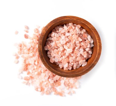 Beyaz arkaplana yerleştirilmiş ahşap bir kasede pembe kaya tuzu kuşbakışı bir bakış at.