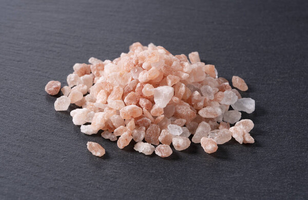 Угловой кадр розовой каменной соли на черном фоне
