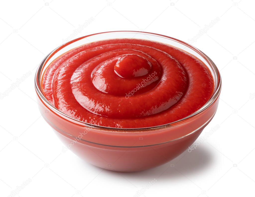 Angled shot of ketchup in a glass bowl on a white background