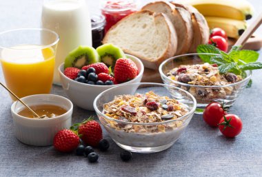Granola, ekmek, meyve ve meyve suyunun görkemli bir kahvaltısının görüntüleri