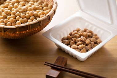 Natto, soya fasulyesi ve çubukları ahşap bir arka plana yerleştirilmiş. Japonya 'da kahvaltı görüntüsü