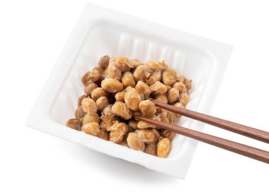 Beyaz arka planda Natto paketleri ve çubuklar