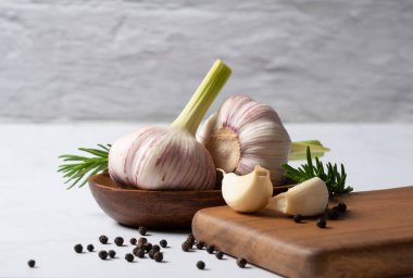 Misket masasında taze sarımsak, bitkiler ve baharatlar. Sarımsaklı yemek yapma görüntüsü.