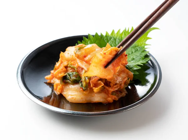 泡菜放在一个白色背景的盘子里 用筷子提起 — 图库照片