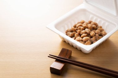 Natto ve çubuklar tahta bir arka plana yerleştirilmiş. Japonya 'da kahvaltı görüntüsü