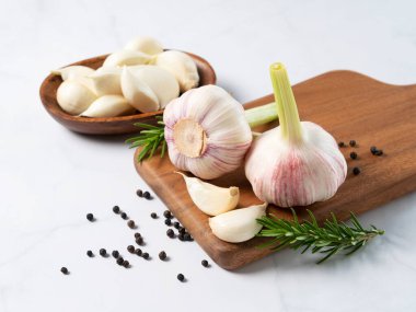 Misket masasında taze sarımsak, bitkiler ve baharatlar. Sarımsaklı yemek yapma görüntüsü.