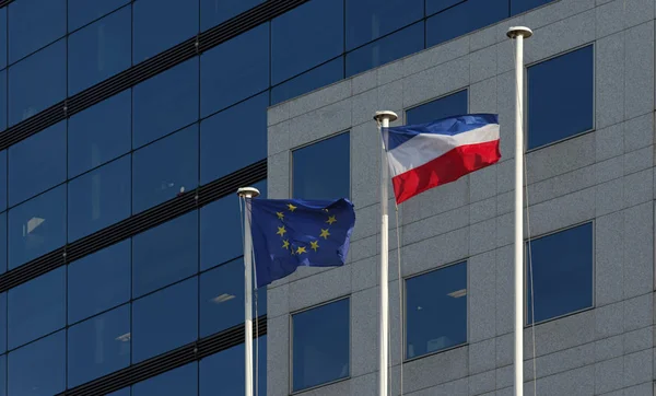 European Union Flag and French Flag on modern building facade in Paris