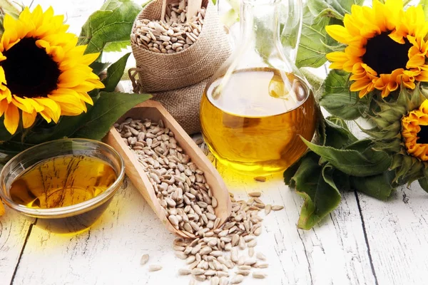 Zonnebloemolie, zonnebloem en zaden op witte achtergrond — Stockfoto