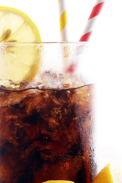 Nealkoholický nápoj s kostkami ledu, citrónem a slámou ve skle — Stock fotografie