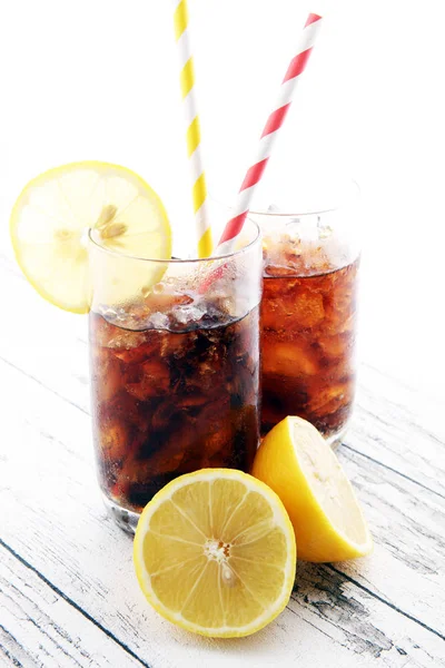 Nealkoholický nápoj s kostkami ledu, citrónem a slámou ve skle — Stock fotografie