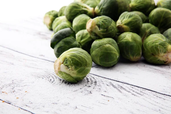 Viele frische Rosenkohl-Sprossen über weißem Holz — Stockfoto