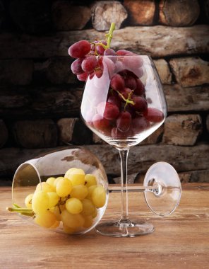 Kadehlerin beyaz üzüm ve ahşap adam üzerinde kırmızı üzüm ile