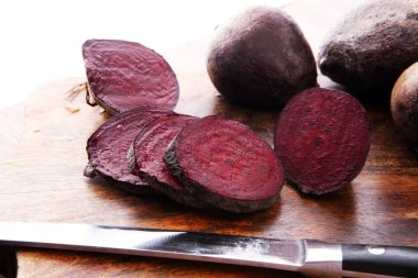 ahşap arka plan üzerinde bir kesme tahtası üzerinde çiğ kırmızı pancar