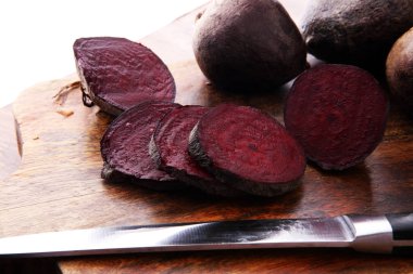 ahşap arka plan üzerinde bir kesme tahtası üzerinde çiğ kırmızı pancar