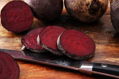 ahşap arka plan üzerinde bir kesme tahtası üzerinde çiğ kırmızı pancar