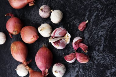 koyu arka plan üzerinde birçok sarımsak ve soğan sebze.