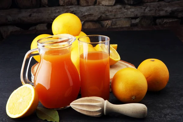 Glass jar of fresh orange juice with fresh fruits on dark table. — Stock Photo, Image