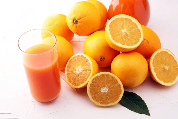 Jarra de vidro de suco de laranja fresco com frutas frescas na mesa branca — Fotografia de Stock