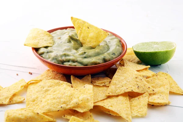 Cuenco de guacamole con chips de tortilla sobre fondo blanco . — Foto de Stock