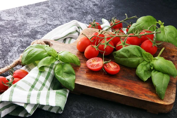 Cherry rajčata s bazalkou a miskou towl na prkénku — Stock fotografie