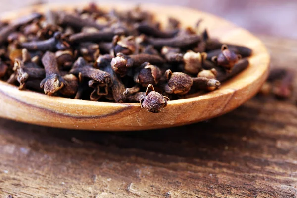 Many Dry cloves spice on wooden spoon — Stock Photo, Image