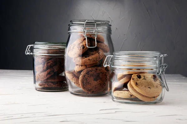 Galletas de chocolate en un frasco de vidrio sobre fondo blanco — Foto de Stock