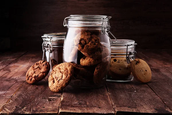 Galletas de chocolate en un frasco de vidrio sobre fondo blanco — Foto de Stock