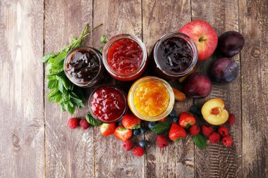 assortment of jams, seasonal berries, plums, mint and fruits. clipart