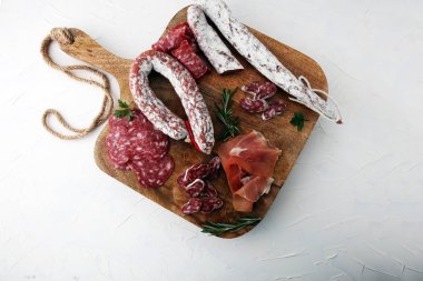 Jambon, salam, sosis ve ros ile ahşap kesme tahtası