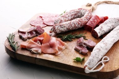 Jambon, salam, sosis ve ros ile ahşap kesme tahtası