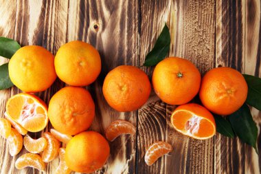 ahşap masa yapraklarda ile taze mandarin portakal meyve
