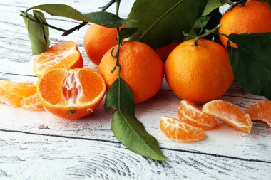 ahşap masa yapraklarda ile taze mandarin portakal meyve