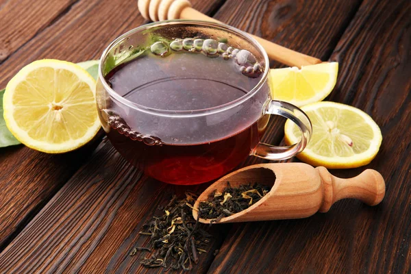 Üveg csésze forró teát citrommal barna fa háttér. — Stock Fotó