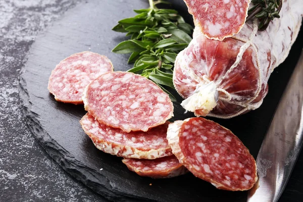 Marmor skärbräda med skivad salami på det. — Stockfoto