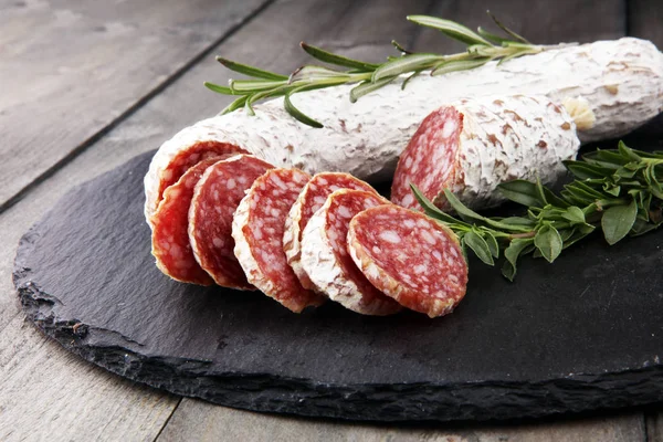 Tabla de cortar piedra con salami en rodajas . — Foto de Stock