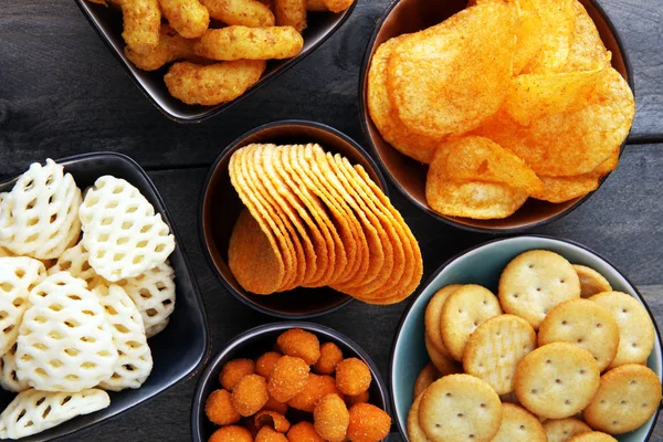 Petiscos salgados. Pretzels, batatas fritas, bolachas em taças . — Fotografia de Stock