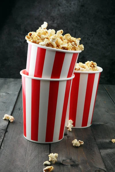 Papper kopp i rött och vitt med popcorn på trä bakgrund. — Stockfoto