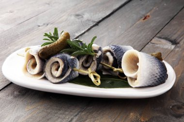 Geleneksel rollmops dolması, salamura ringa balığı filetosu, bir tabak üzerinde.
