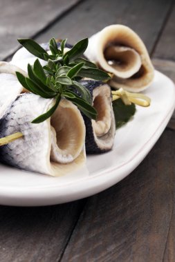 Geleneksel rollmops dolması, salamura ringa balığı filetosu, bir tabak üzerinde.